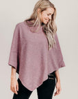 Woman wearing a petal poncho with black pants