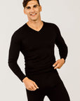 A man wearing a black long-sleeved merino wool V-neck sweater.
