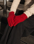 Person wearing red gloves sitting on steps outdoors