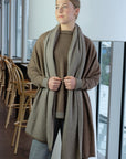 Woman wearing a long brown wrap  in an indoor setting