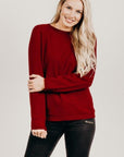 Woman wearing a fire merino silk sweater with black pants