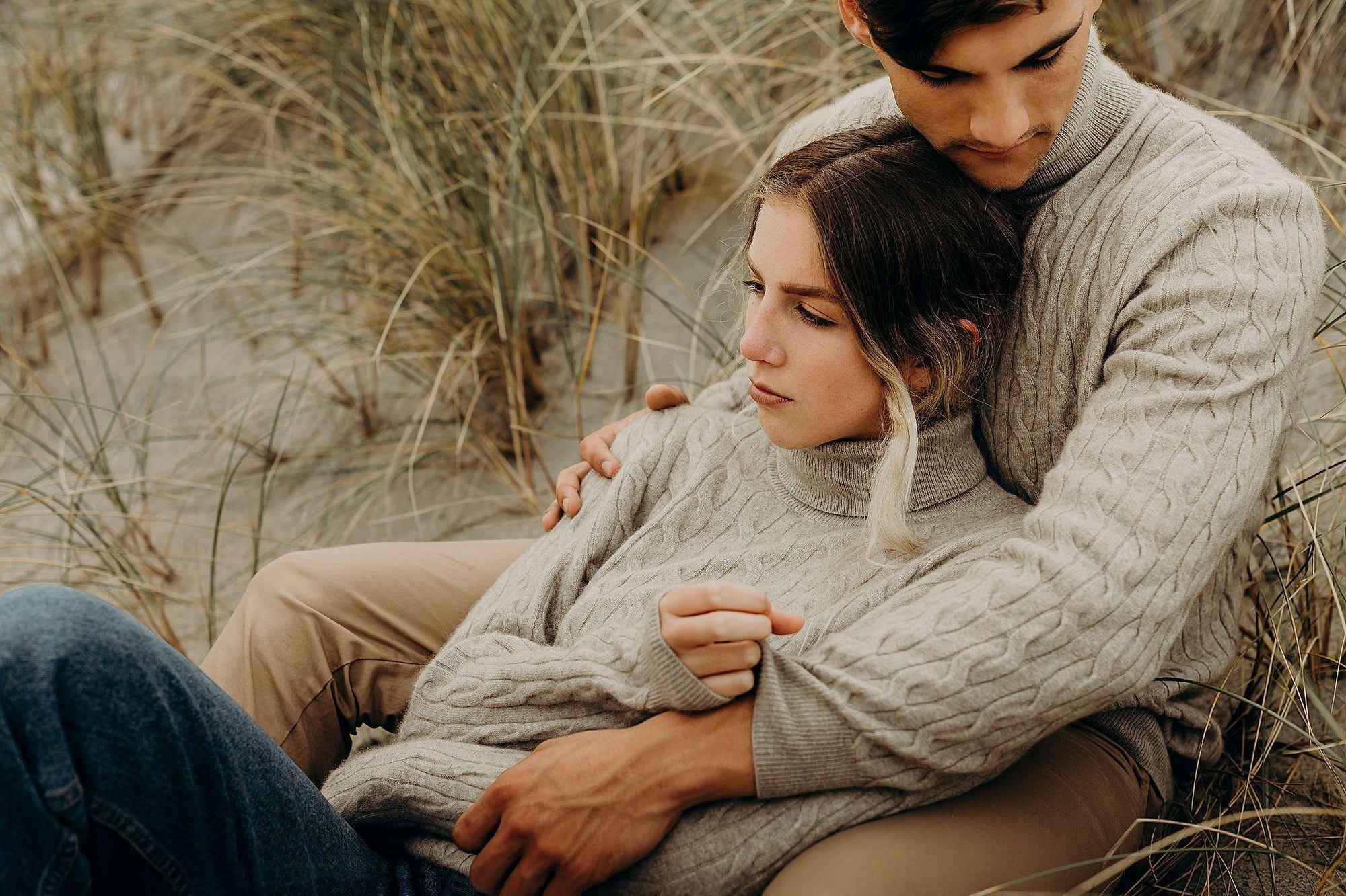 A couple wearing lichen cable turtle neck sweaters