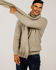 Man wearing lichen cable sweater with matching scarf