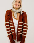 Woman wearing a stripe sweater and a beige scarf.