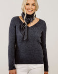 Woman wearing a grey sweater and a grey scarf