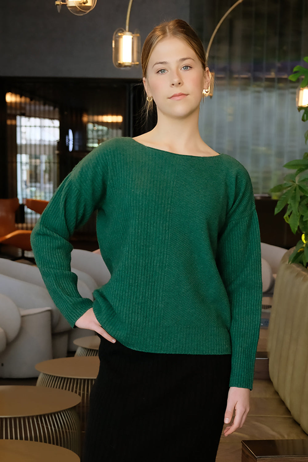 Woman wearing a green sweater in an indoor setting