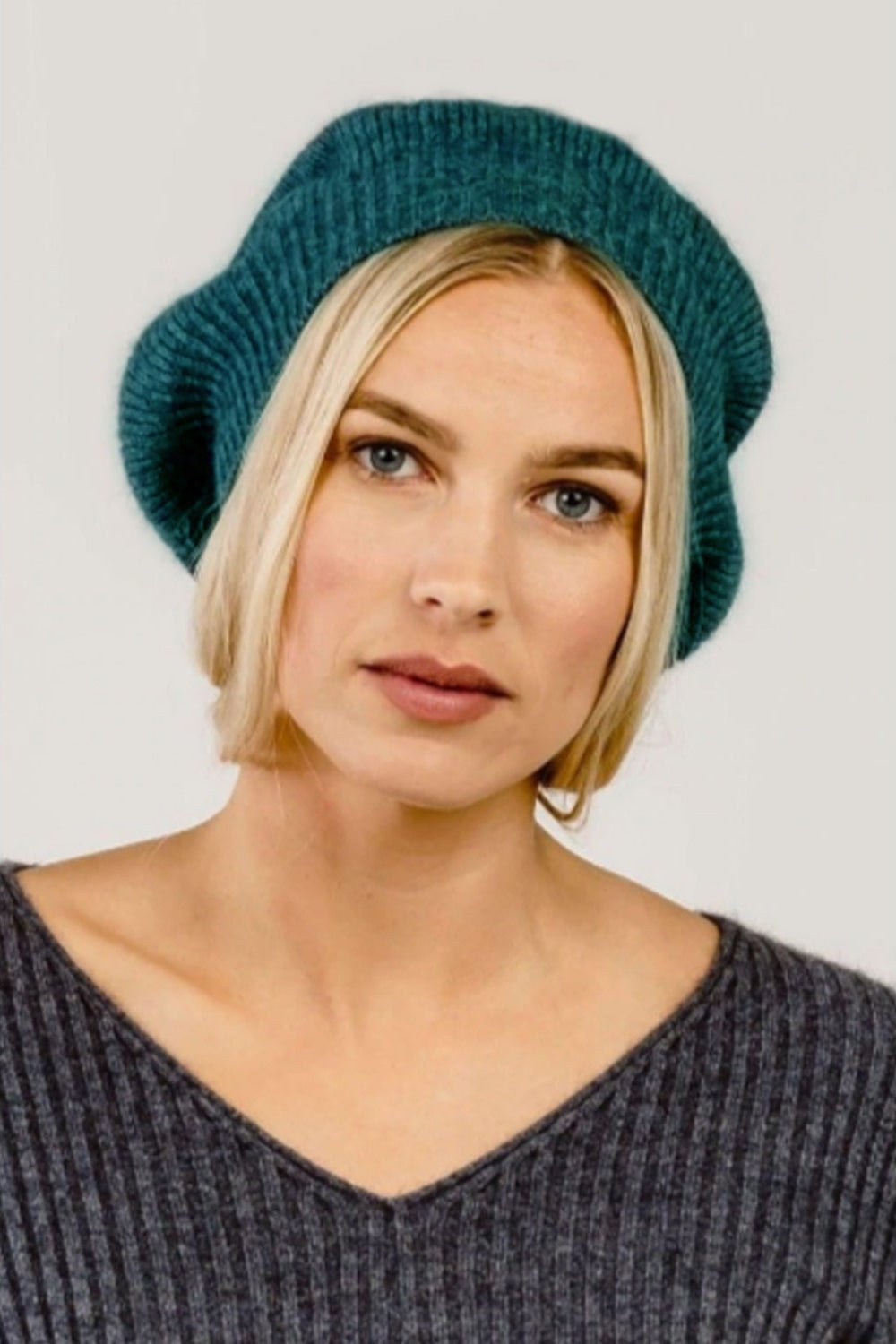 A woman wearing a green Merinosilk beret hat.
