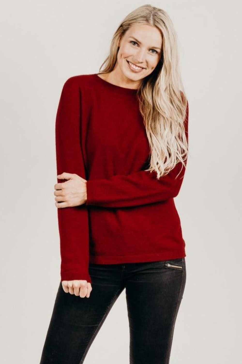 Woman wearing a fire merino silk sweater with black pants