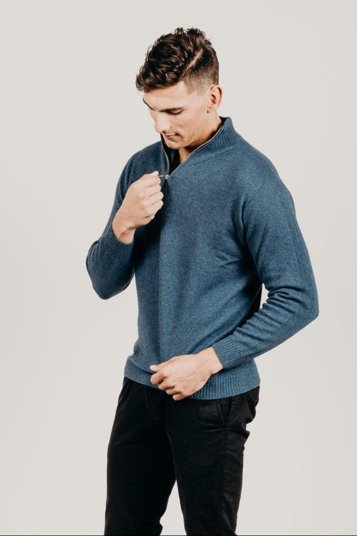 Man wearing a blue sweater against a plain background