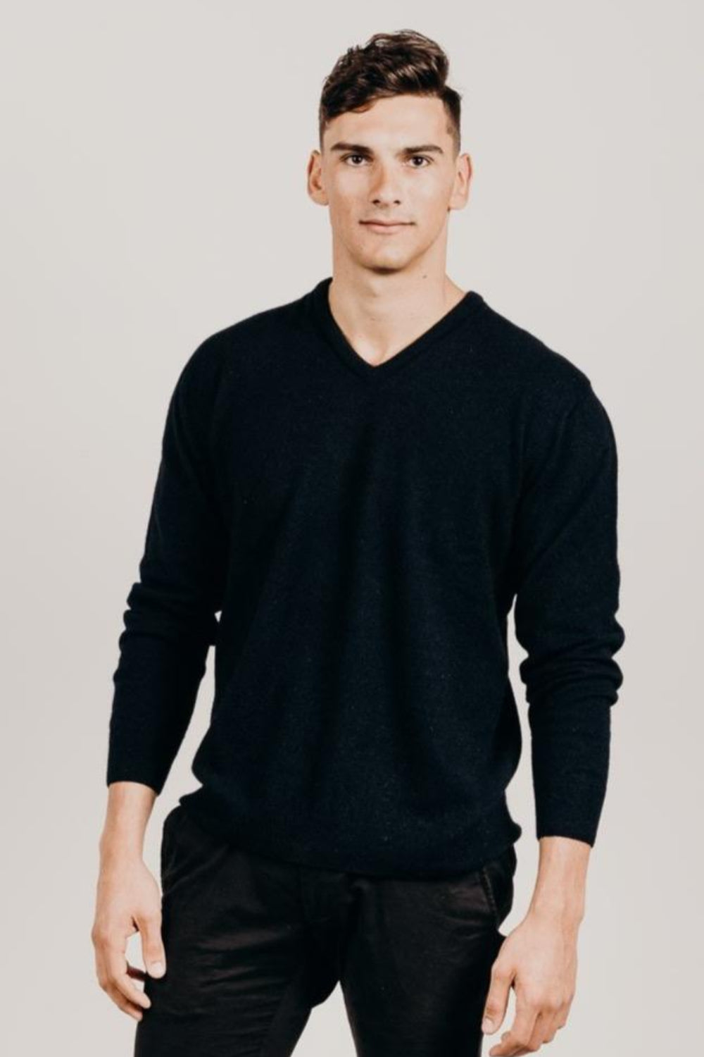 Man wearing a black sweater against a plain background