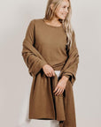Woman wearing a light brown Classic Cervelt Scarf - Kapeka NZ, Made from New Zealand Red Deer Fibre. Very Soft and rare Fibre. Only made in New ZealandCervelt Luxury Sweater - Kapeka NZ