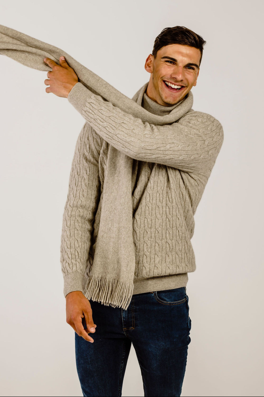 Man wearing lichen cable sweater with matching scarf