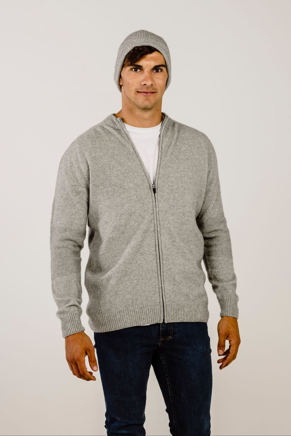 Man wearing a gray zip-up hoodie and beanie on a white background