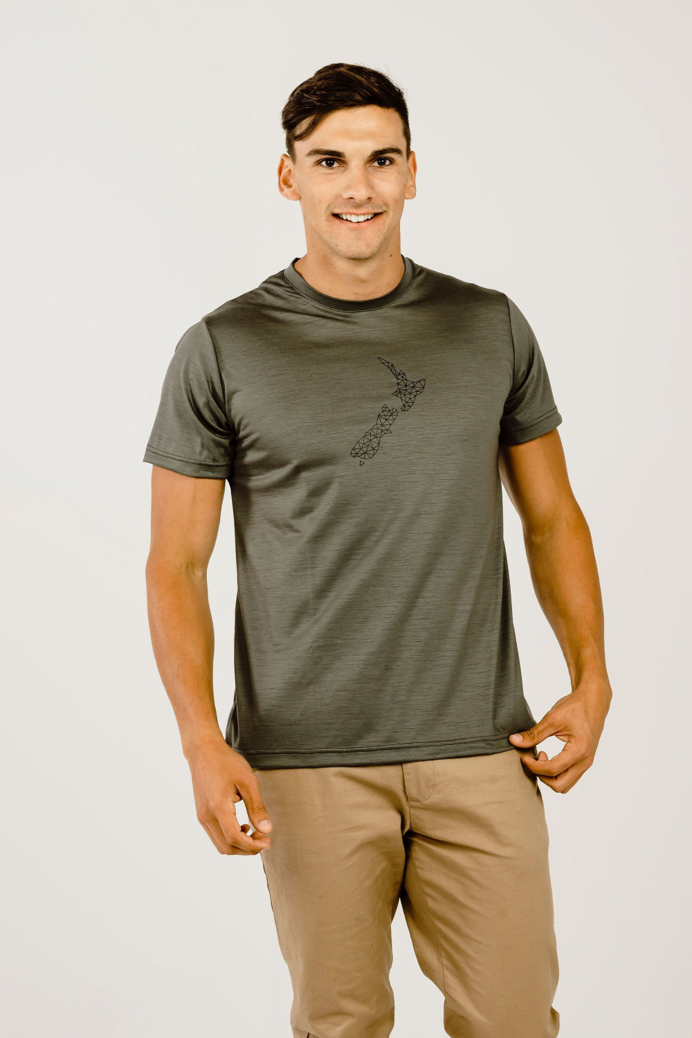 A male model wearing a short-sleeved green Merino wool t-shirt with a crew neckline, standing against a plain background.